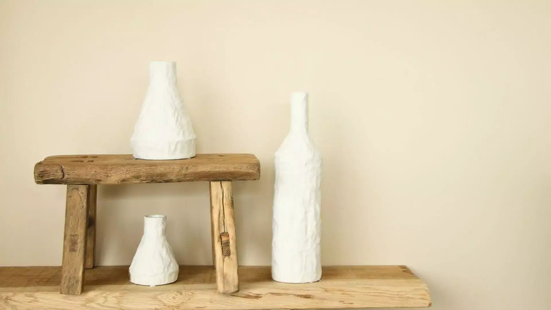 Vases en céramique blanche sur étagère en bois naturel, décoration minimaliste et élégante.